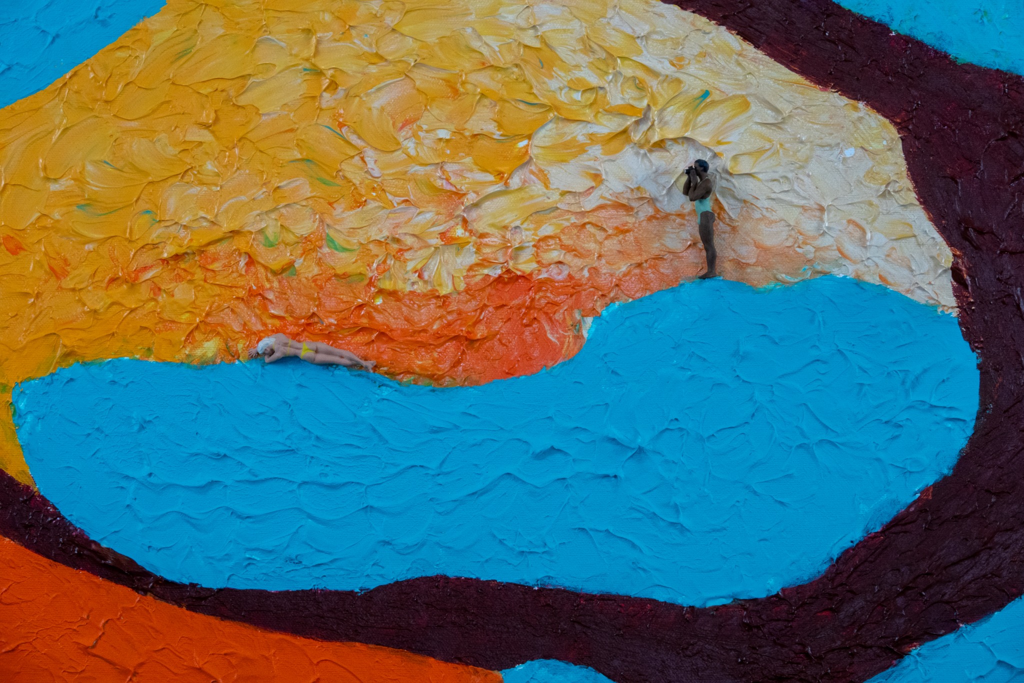 Detail of a colourful relief painting with two miniature figures. One is lying down, the other is standing.