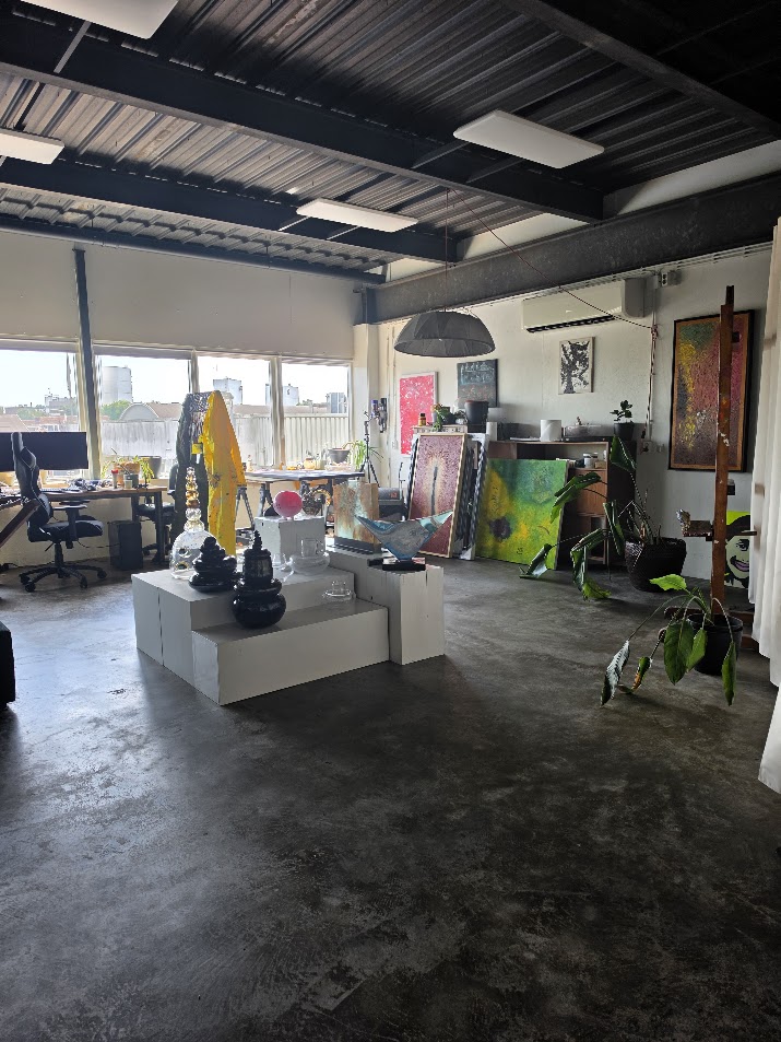 Ward’s studio with paintings, a work table and art objects.